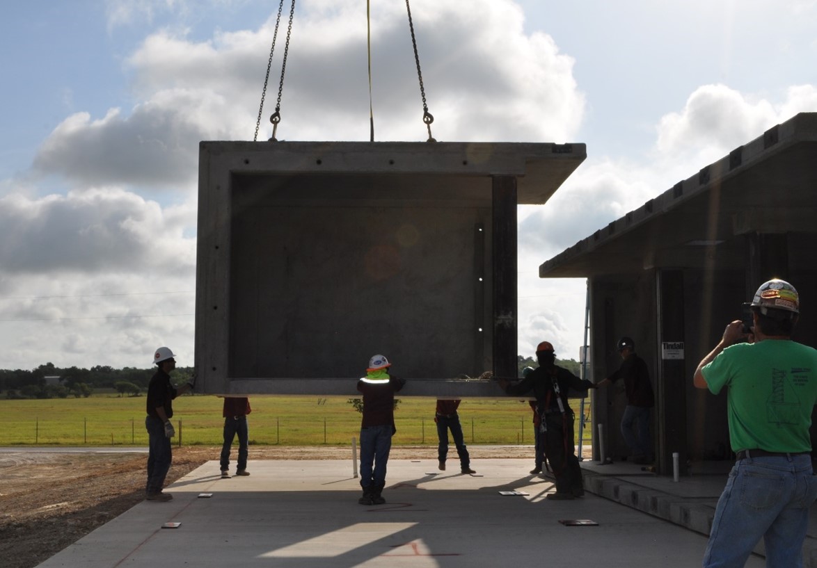 Construction workers installing a precast concrete building