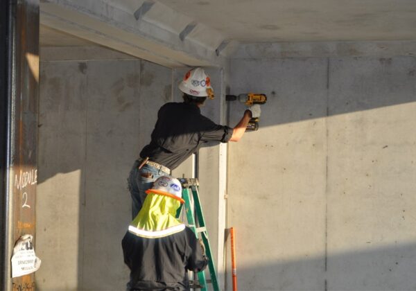 Construction workers installing a precast concrete building